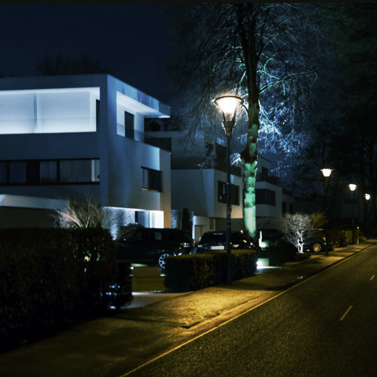 AEH3 LED Garden Post Light Modern Black Cone Frame Design Installed Along Residential Street at Night Providing Warm White Illumination for Urban Pathway Lighting