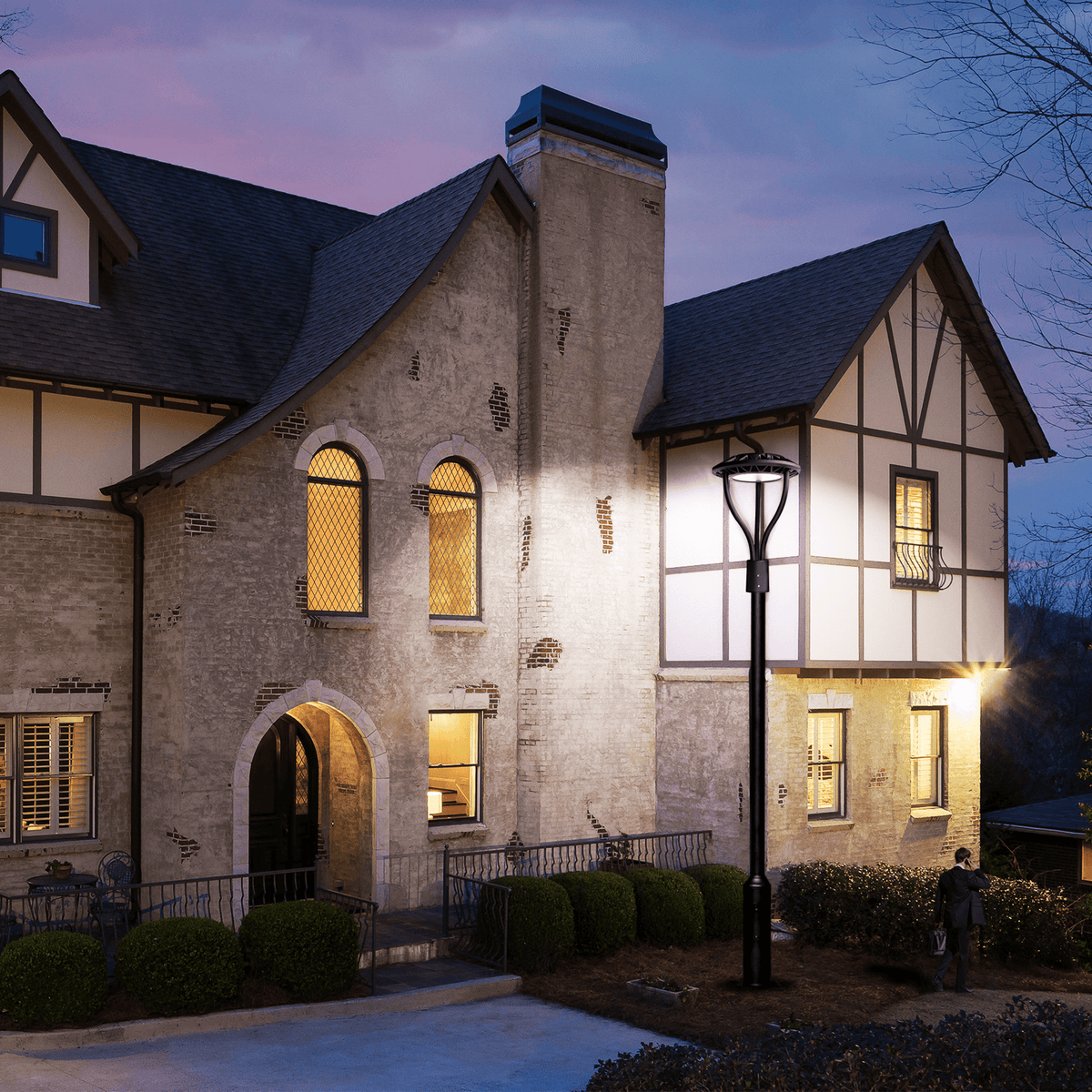 AEH2 LED Garden Post Light Installed at Tudor-Style Mansion Entrance at Dusk Providing Bright White Illumination for Residential Driveway and Facade Lighting

